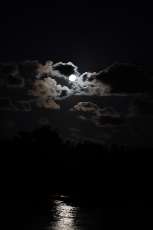 Photo of the moon as it rises higher in the sky and reflects on the intracoastal. Great clouds.